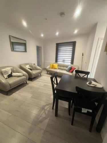 ein Wohnzimmer mit einem Tisch und einem Sofa in der Unterkunft EEJs Modern 3 bed flat near Crystal Palace Stadium with great transport links in Norwood