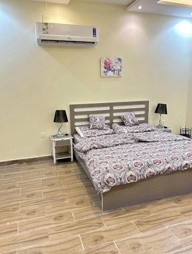 a bedroom with a bed and a air conditioner on the wall at شاليهات بيوتي in Umm Salam
