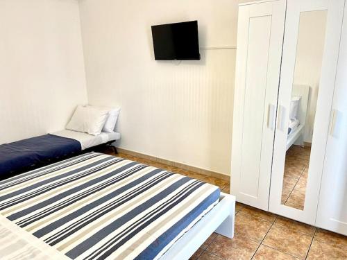 a small room with a bed and a tv at Casa Vacanze La Baia in Messina