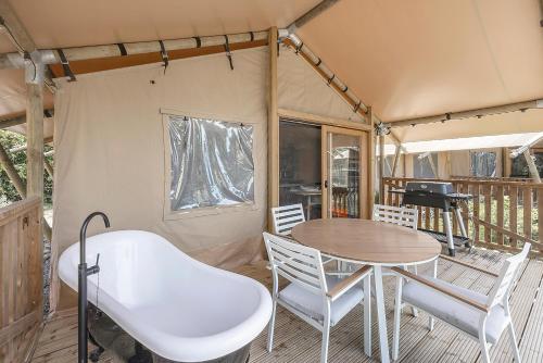 a tent with a table and chairs on a deck at Reflections Lennox Head - Holiday Park in Lennox Head
