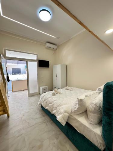 a bedroom with a large bed and a television at Troy ApartHotel Durres in Durrës