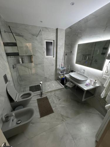 een badkamer met een douche, een toilet en een wastafel bij Center View Luxury Apartment in Tirana