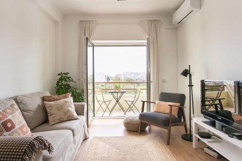 a living room with a couch and a balcony at Apartamento central Setúbal sossegado e com luz in Setúbal