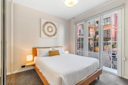 - une chambre avec un lit et une grande fenêtre dans l'établissement Private 2-Bed in St Kilda's Heart with Courtyard, à Melbourne