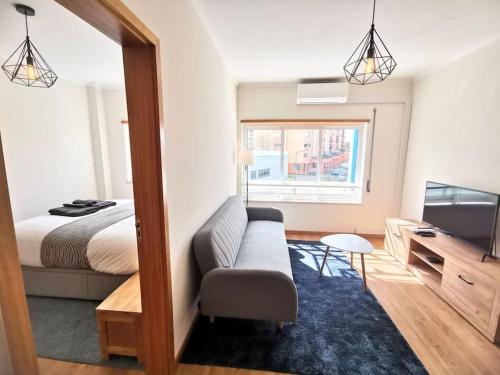 a bedroom with a bed and a couch and a tv at new sunny house! your home Lisbon apartment in Lisbon