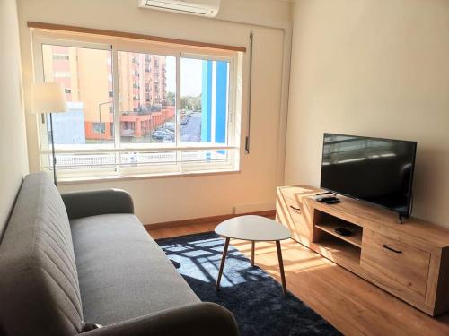 a living room with a couch and a flat screen tv at new sunny house! your home Lisbon apartment in Lisbon