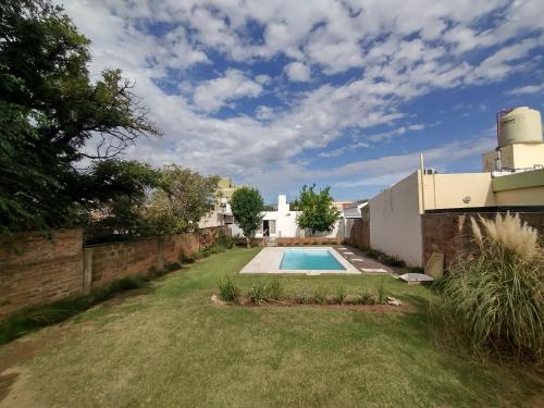 a backyard with a swimming pool and a house at Casa Lo de Juan in Santa Rosa