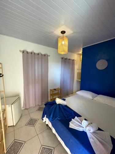 a bedroom with a large bed with a blue wall at Pousada Vila Nativa in Arraial d'Ajuda