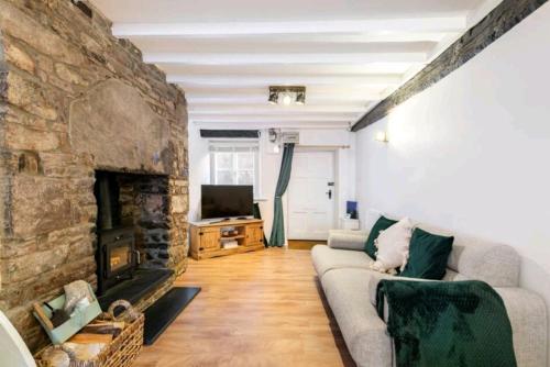 a living room with a couch and a stone fireplace at The Cwtch in Brecon