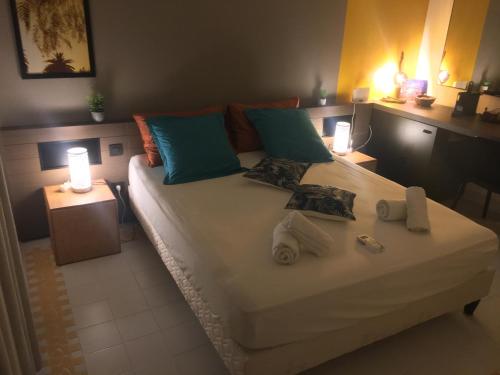 a bedroom with a bed with towels on it at Good Mood Studio - Manganao in Saint-François