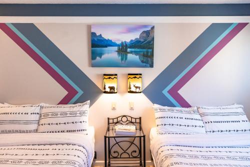a bedroom with two beds and a painting on the wall at Astoria Hotel in Jasper