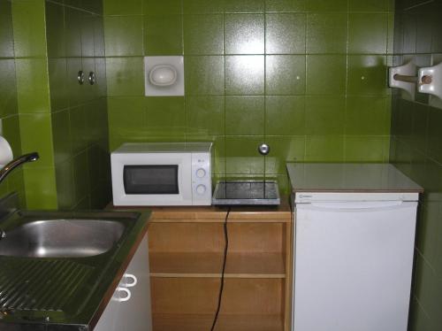 a small kitchen with a sink and a microwave at Doge Inn in Ronchi dei Legionari