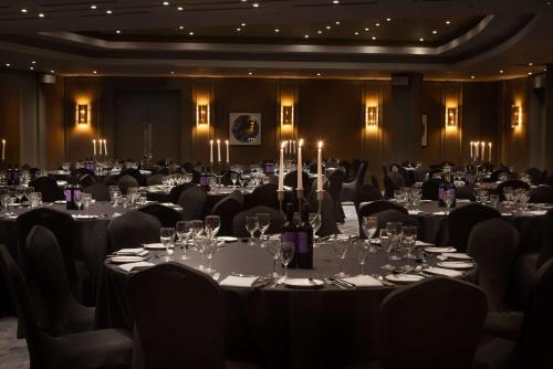 a banquet room with tables and chairs with wine glasses at Hilton Cardiff in Cardiff