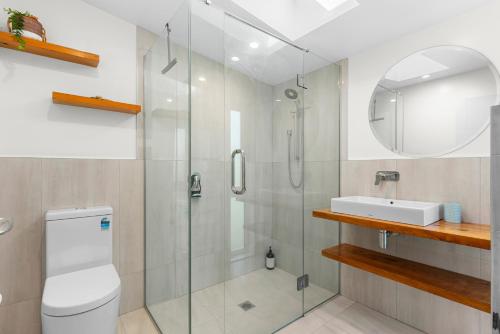 een badkamer met een douche, een toilet en een wastafel bij The Daydreamer - Mangawhai Heads Holiday Home in Mangawhai