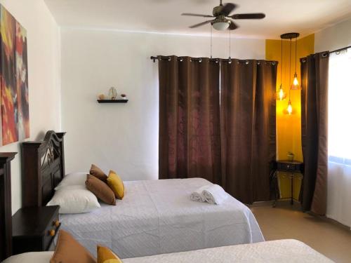 コパン・ルイナスにあるMayan Plaza Hermosa Habitación a 3 cuadras del Parqueのベッドルーム1室(ベッド2台、シーリングファン付)