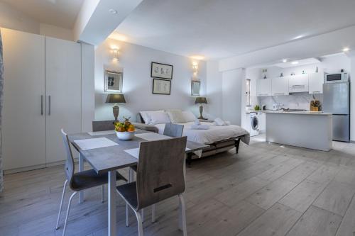 a living room with a bed and a table and chairs at Bahar ic-Caghaq Apartment with private drive-in, equidistant from Sliema and St. Paul's Bay in Naxxar
