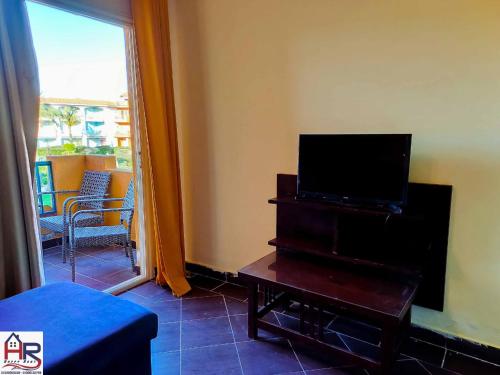 uma sala de estar com uma televisão numa cómoda e uma mesa com uma televisão em Porto Matroh For Family em Marsa Matruh