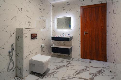Sofy hotel في Bouira: حمام ابيض مع مرحاض ومغسلة