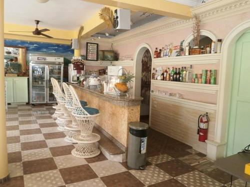 a kitchen with a bar with a checkered floor at Hotel Mango in Boca Chica