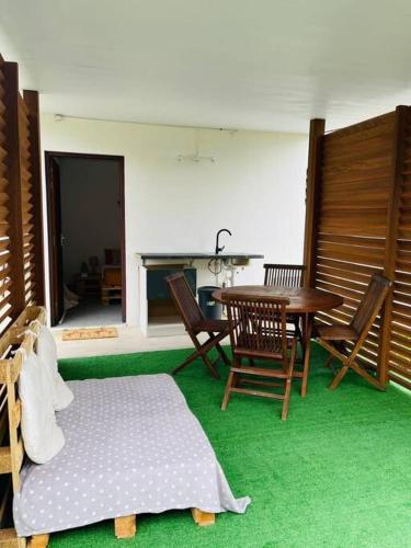 een woonkamer met een tafel en stoelen bij Paisible studio tout confort in Matoury