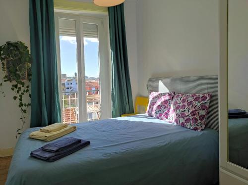 - une chambre avec un lit et une grande fenêtre dans l'établissement Be Local - Charming flat with 2 bedrooms on Lisbon's 7th hill, à Lisbonne