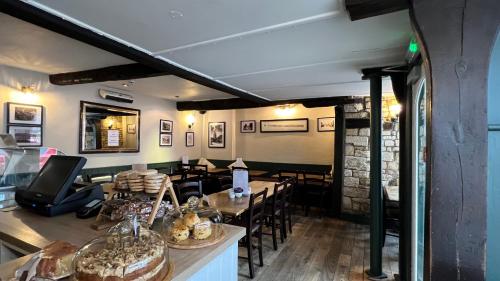 a restaurant with tables and chairs in a room at Priory Tearooms Burford with Rooms in Burford