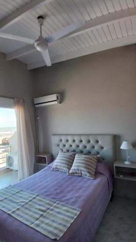 a bedroom with a purple bed with a ceiling at Cómodo dúplex frente al mar in Monte Hermoso