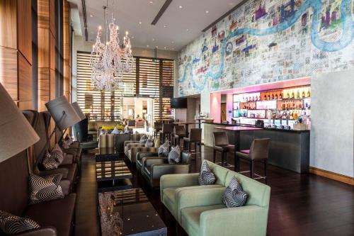 ein Restaurant mit einer Bar mit Sofas und einer Bar sidx sidx sidx in der Unterkunft Hilton London Heathrow Airport Terminal 5 in Hillingdon