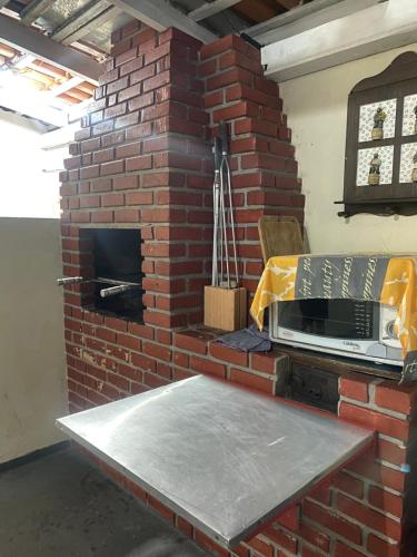 a brick wall with a microwave on top of it at Casa Completa 2 Quartos in Penha