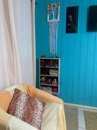 a room with a blue wall and a couch at Casa Completa 2 Quartos in Penha