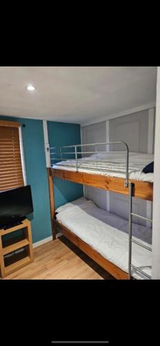 two bunk beds in a room with a desk at 2 Bedroom Chalet Isle of Sheppey Holiday Village in Kent