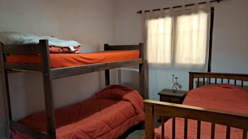 a bedroom with two bunk beds and a window at La casa Roja in San Carlos