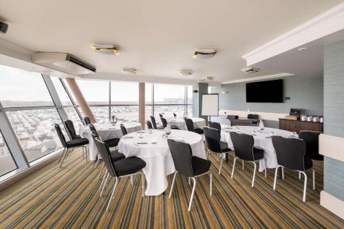 a conference room with white tables and chairs and a flat screen tv at DoubleTree by Hilton Hotel Newcastle International Airport in Newcastle upon Tyne