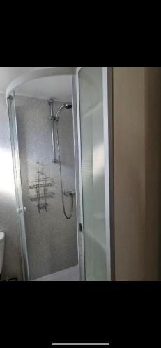 a shower in a bathroom with writing on the wall at 2 Bedroom Chalet Isle of Sheppey Holiday Village in Kent