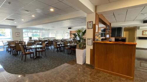 um restaurante com mesas e cadeiras e um bar em Auckland Airport Kiwi Motel em Auckland