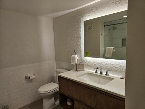 a bathroom with a sink and a toilet and a mirror at Attractive Modern Unit by Flamingo Strip Las Vegas in Las Vegas