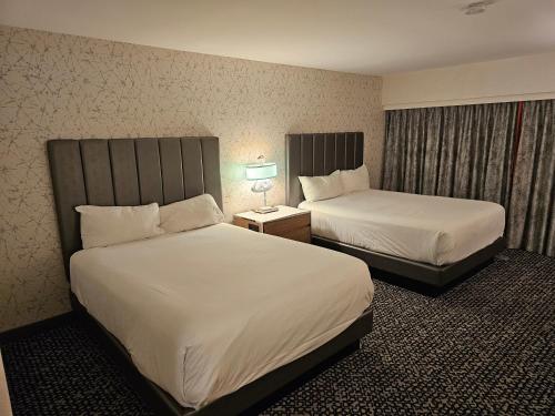 a hotel room with two beds and a lamp at Attractive Modern Unit by Flamingo Strip Las Vegas in Las Vegas
