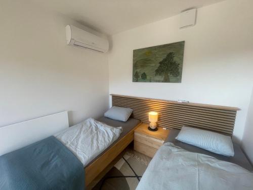 Dormitorio pequeño con 2 camas y lámpara en Luxury Holiday House BREJZOV BREJG en Dankovci