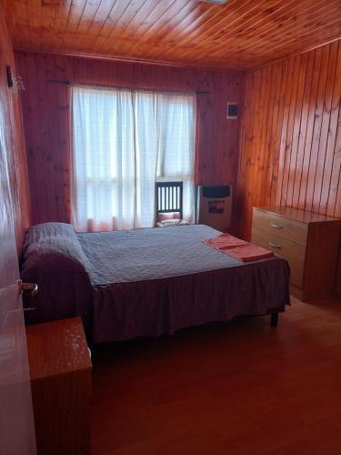 Un dormitorio con una cama grande y una ventana en Carla en Puerto Santa Cruz