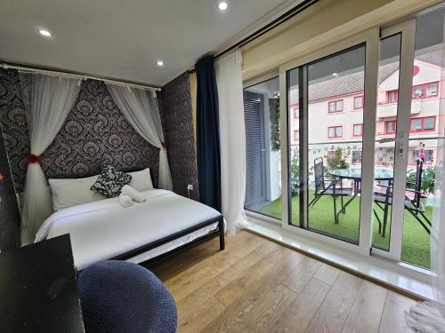 a bedroom with a bed and a large window at East London Guest House in London