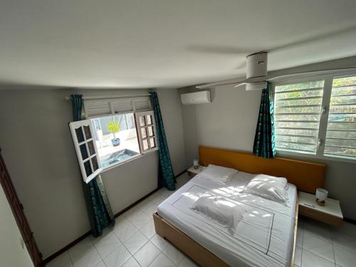 sypialnia z łóżkiem i oknem w obiekcie Appartement vue sur piscine chez Lise et Roro w mieście Pointe-Noire