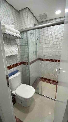 a bathroom with a toilet and a glass shower at Flat confortável com recepção 24h e vaga de garagem in São Paulo