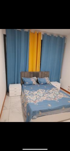 a bedroom with a bed with blue and yellow curtains at Pensão lopes in São Tiago