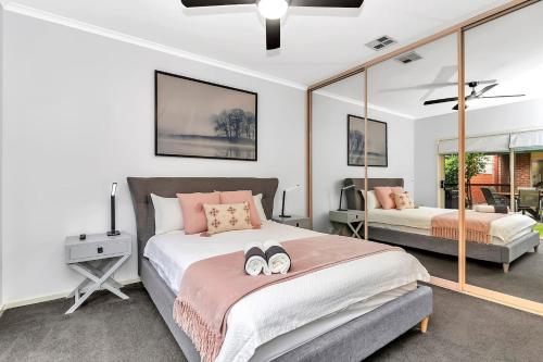 1 Schlafzimmer mit 2 Betten und einem Spiegel in der Unterkunft Brompton Bliss - A Relaxed Northern Adelaide Retreat in Bowden