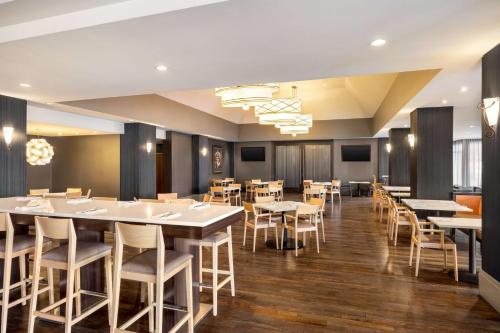 a dining room with white tables and chairs at Hilton Vancouver Airport in Richmond