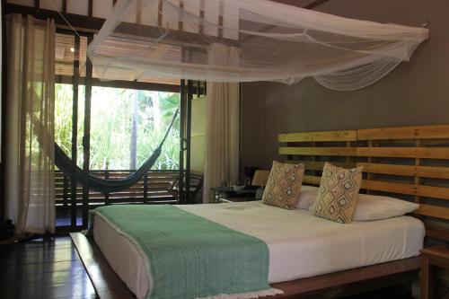 a bedroom with a bed with a canopy and a window at Hotel Luz de Luna in Santa Teresa Beach