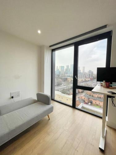 a living room with a couch and a large window at Cheap ROOM with great Canary Wharf city view in London