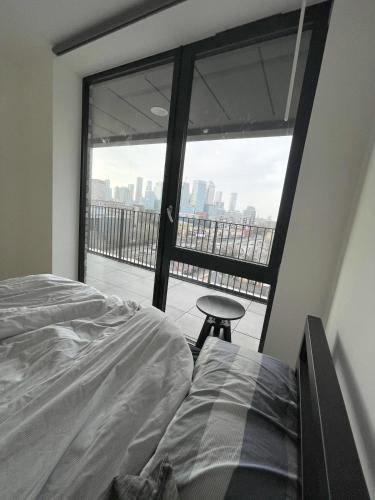 a bedroom with a bed and a view of the city at Cheap ROOM with great Canary Wharf city view in London