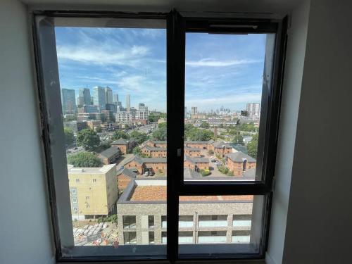 a window with a view of a city at Cheap ROOM with great Canary Wharf city view in London