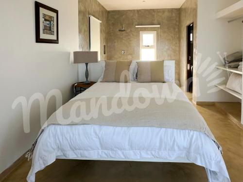 a bedroom with a large white bed in a room at Mandowa Prepayment Required in Praia de Macaneta